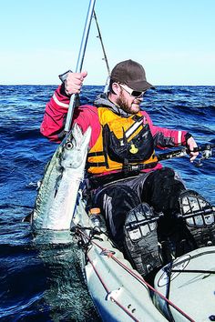 a man in a kayak holding a fish