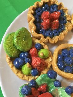 three small bowls filled with fruit on top of a white plate