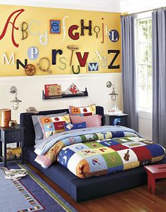 a child's bedroom decorated in bright colors and alphabet wall decals on the walls