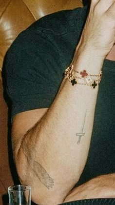 a man with a cross tattoo on his arm