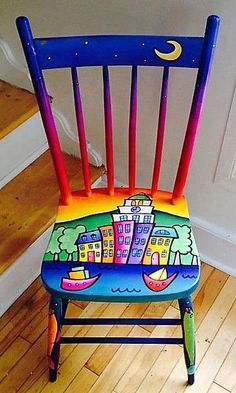 a colorful wooden chair sitting on top of a hard wood floor