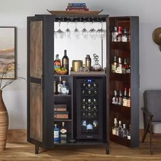 an open cabinet with wine glasses and liquor bottles in it, sitting on a wooden floor