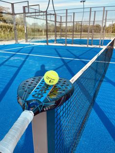 a tennis racket and ball on a blue court