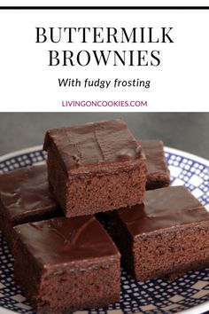 chocolate brownies with fudge frosting are stacked on a blue and white plate