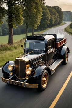 an old model truck driving down the road with trees in the backgrouund