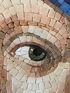 an eye is shown in the center of a mosaic design