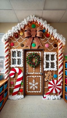 a gingerbread house decorated for christmas with candy canes and decorations on the front door