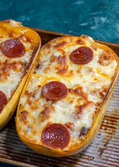 two slices of pepperoni pizza sitting on top of a baking pan next to each other