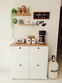 a coffee bar with white cabinets and wooden shelves