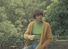 a woman sitting on a bench with a bowl in her hand