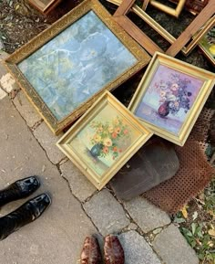 there are many framed pictures on the ground next to each other and one pair of shoes