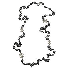 CHANEL by KARL LAGERFELD ruthenium tone necklace featuring a strand of grey faux pearls with four silver tone CHANEL CC logos embellished with clear crystals. Can be wrapped two times around the neck. Lobster clasp closure. Laser mark CHANEL B14 C Made Made in Italy. Indicative measurements : total length approx. 129 cm (50.79 inches) / largest CC logo approx. 2.1 cm x 1.5 cm (0.83 inch x 0.59 inch) / smallest CC logo approx. 1.5 cm x 1.1 cm (0.59 inch x 0.43 inch). Materials : Ruthenium tone metal hardware / Silver tone metal hardware / Faux pearl / Crystal. NOTES - This is a preloved vintage item, therefore it might have imperfections. - Colors may differ slightly from actual product appearance due to differences in lighting conditions. - As a buyer, you are fully responsible for customs Chanel Pearls, Pearl Jewels, Laser Marking, Clear Crystals, Pearl Grey, Cc Logo, Clear Crystal, Karl Lagerfeld, Faux Pearl