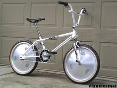 a white bicycle parked in front of a garage door