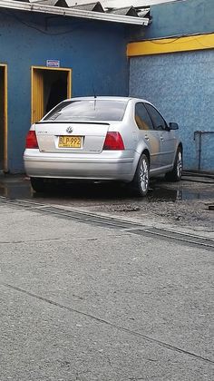 a silver car parked in front of a blue building