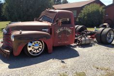 an old red truck parked in front of a house