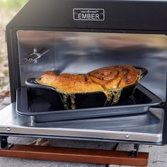 a piece of food is being cooked in an oven on a table top with a wooden base