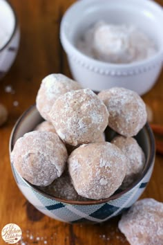 powdered sugar donuts in a bowl on a wooden table