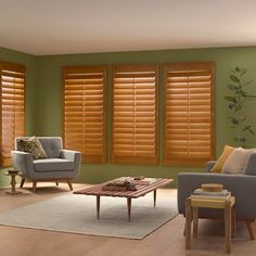 a living room filled with furniture and windows covered in wooden shutters that match the green walls