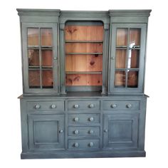 an old china cabinet with glass doors and drawers on the front, painted in blue