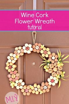 a wine cork wreath is hanging on the front door with pink ribbon and white flowers