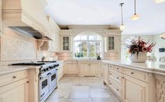 a large kitchen with white cabinets and marble counter tops