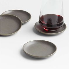 three wine glasses sitting next to each other on plates with one glass in the middle