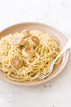 a plate of pasta with scallops on it