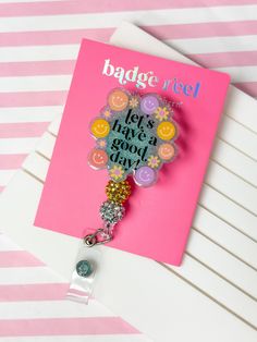 a badge reel attached to a pink and white striped card with the words let's have a good day on it