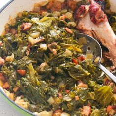 a bowl filled with greens and meat on top of a table