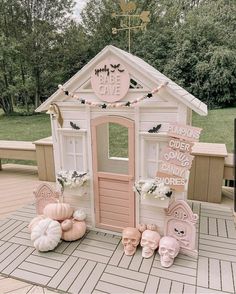 a pink and white doll house with lots of decorations on the front porch for halloween