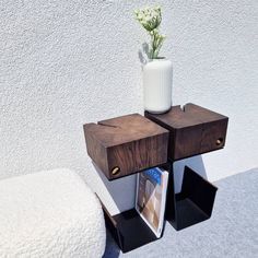 a vase with flowers sitting on top of a wooden shelf