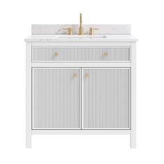 a white vanity with two gold faucets on top