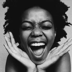 a black and white photo of a woman with her hands on her face, screaming