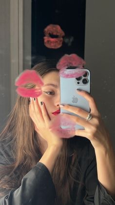 a woman taking a selfie in front of a mirror with pink flowers on it