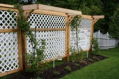 a wooden fence with trelliss and plants growing on the sides in front of it