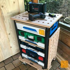 a workbench with various tools on it sitting next to a wooden fence outside