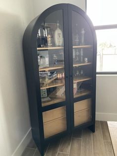 a corner cabinet with glass doors and shelves