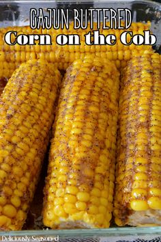 grilled corn on the cob in a glass dish with text overlay that reads, cajun buttered corn on the cob