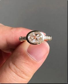 a person holding a ring with a diamond in it's middle and the other hand