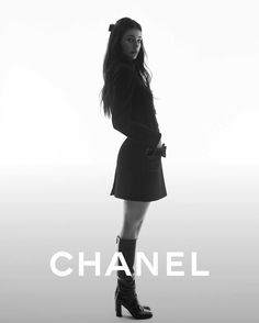 a black and white photo of a woman in high heel boots with the words chanel on it