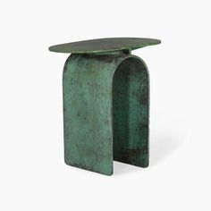 a green metal table with a curved top