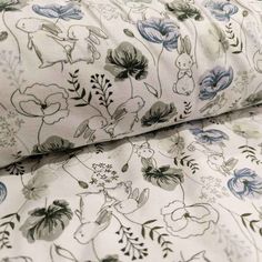 the bedding is made up with blue and white flowers on it, as well as an animal print