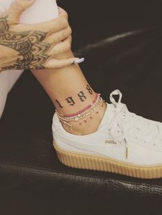 a close up of a person's foot with a tattoo on her left ankle