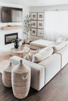 a living room filled with furniture and a flat screen tv mounted on the wall above a fire place