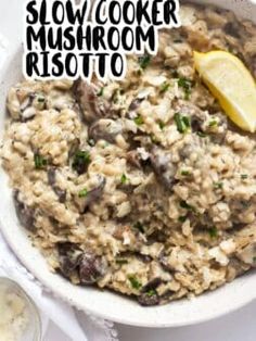 a bowl filled with mushroom risotto next to a lemon wedge and some rice