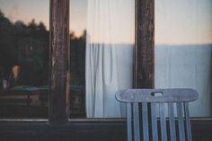 a wooden chair sitting in front of a window