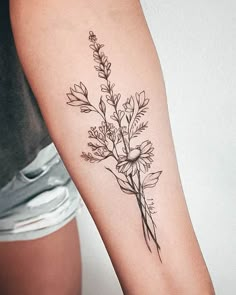 a black and white flower tattoo on the right arm, with small flowers in it