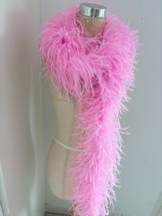 a mannequin wearing a pink feather scarf