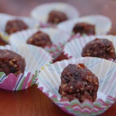 several chocolate balls sitting on top of each other in paper wrappers, ready to be eaten