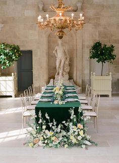 the table is set up with white flowers and greenery for an elegant wedding reception